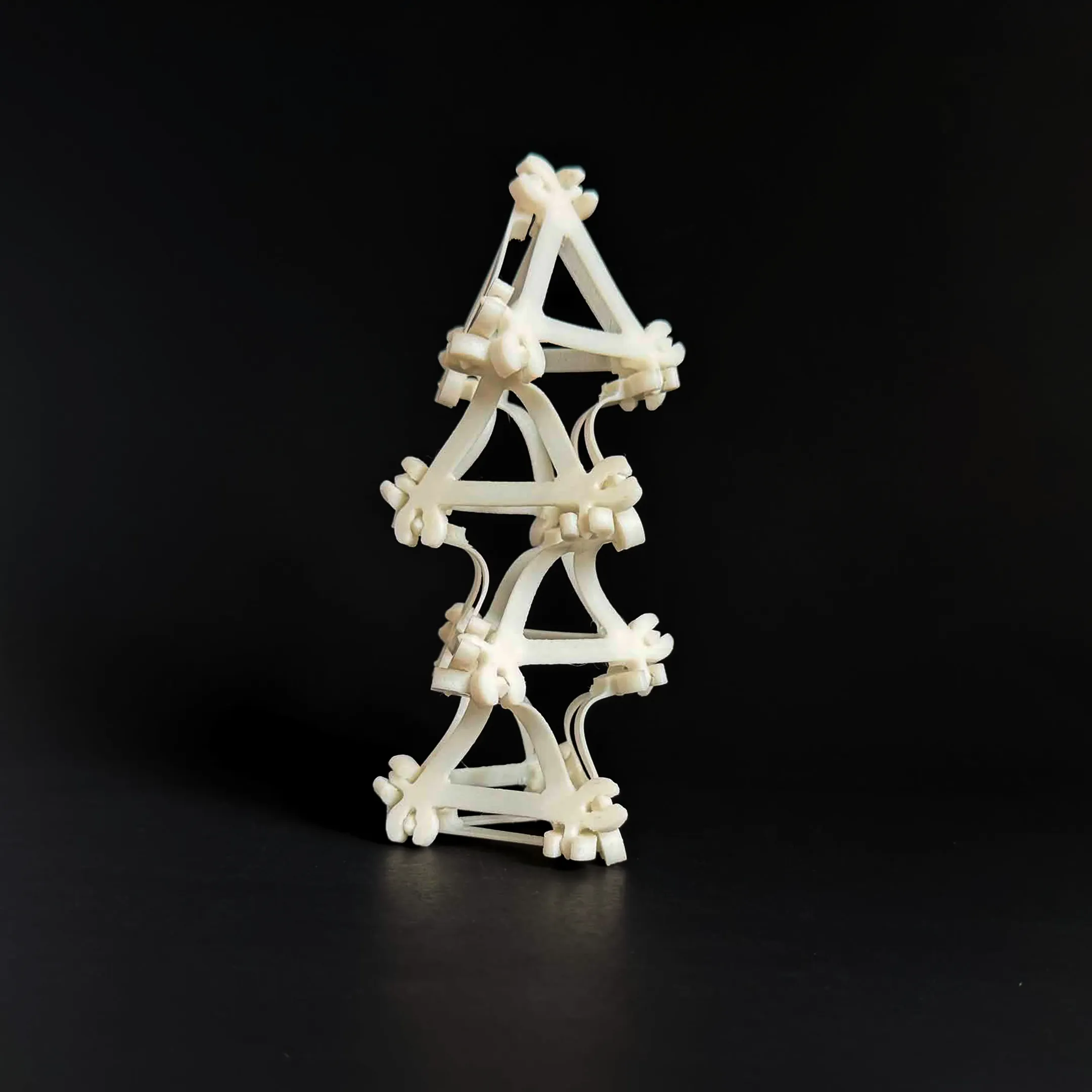 A tall Compliagon tower rising vertically from a dark background.